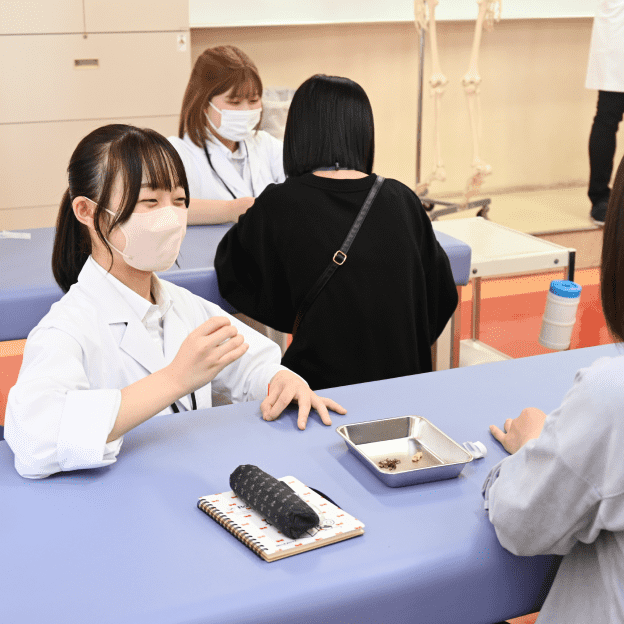 笑顔で話をしている白衣を着た女子学生